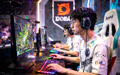 DOTA2国际邀请赛中国区预选赛现场，选手在比赛席位上专注操作